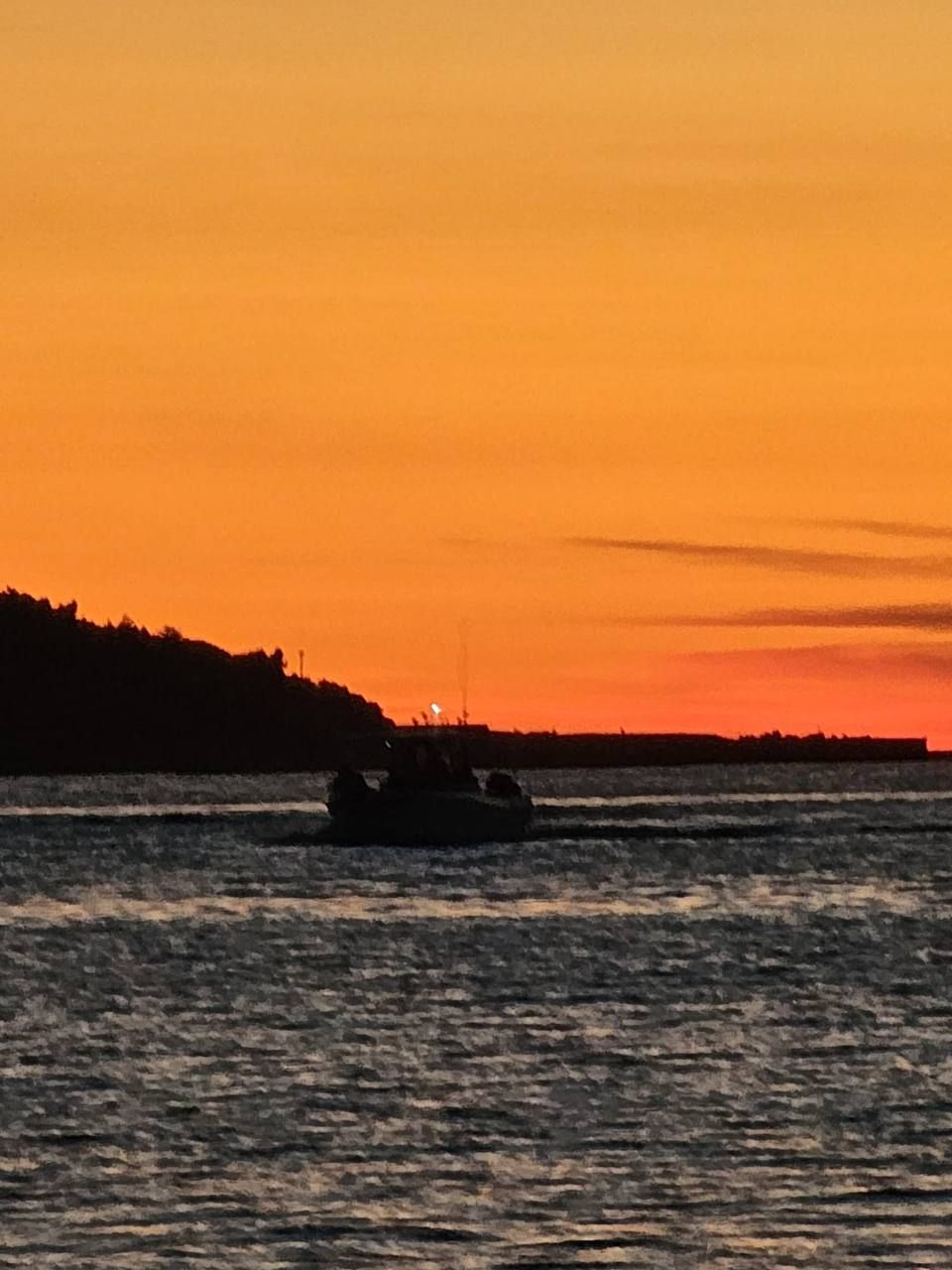 Orange sunset with a boat on the sea
