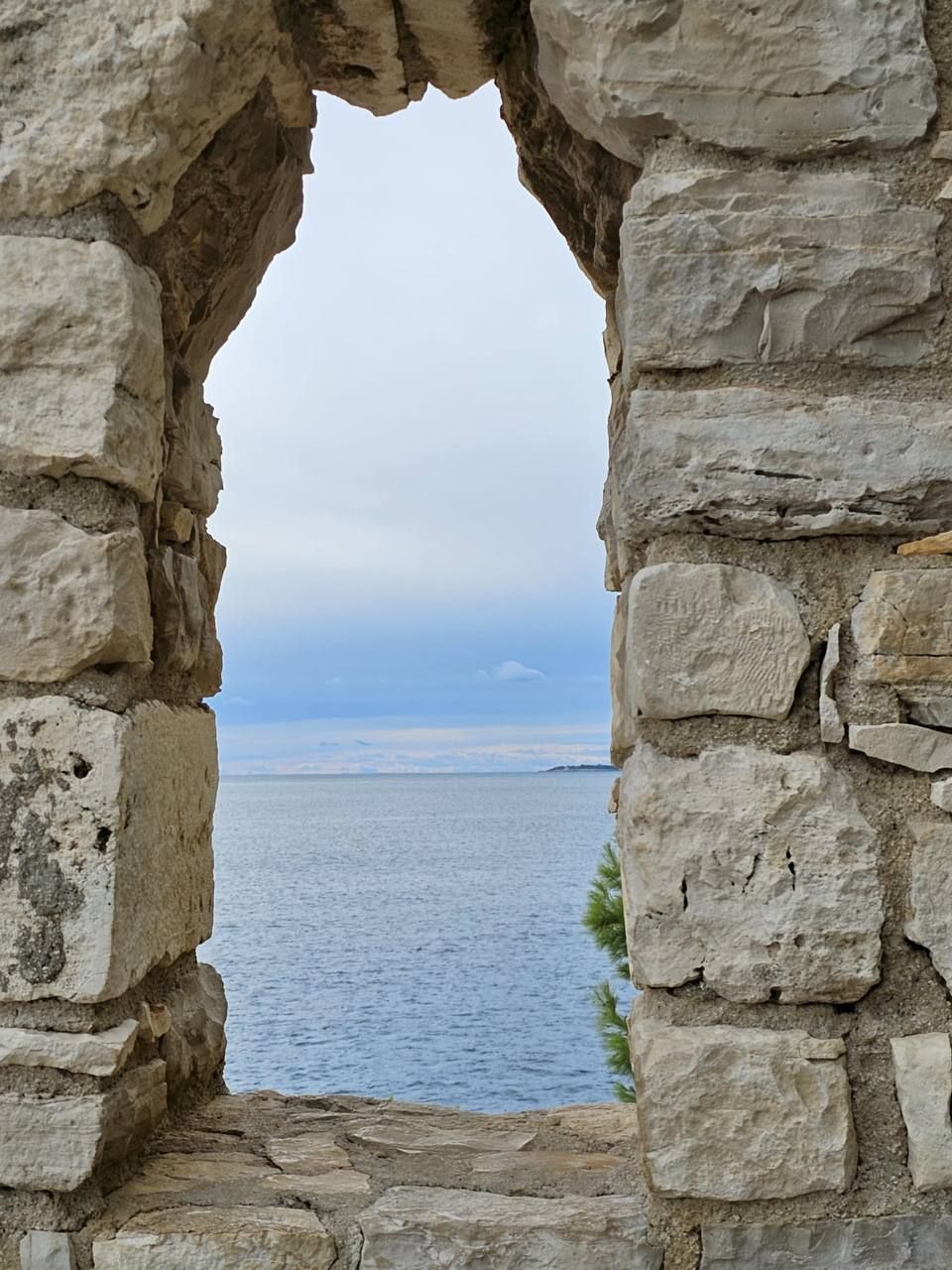 View of the sea through an old stone window